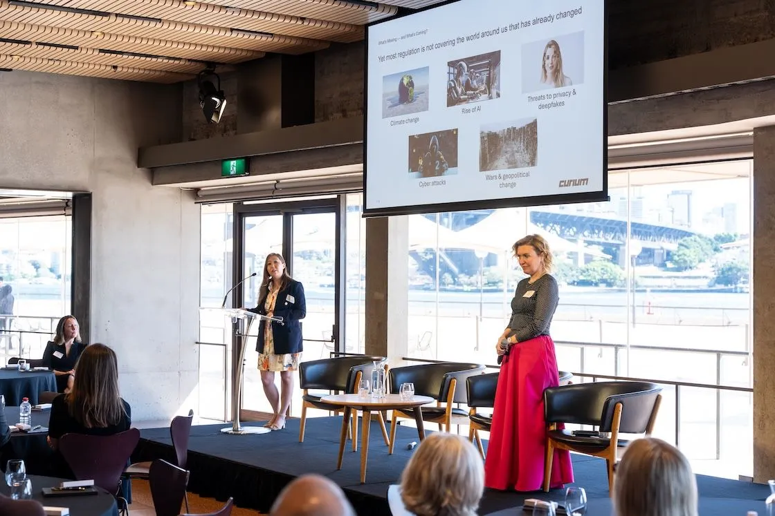 Tetiana George presenting at a Curium event with audience members in a modern venue
