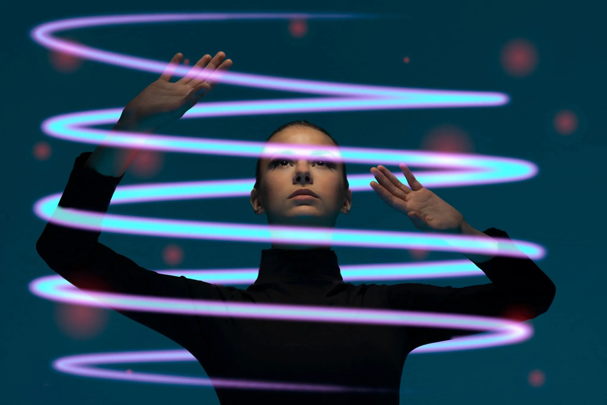 Woman holding her hands up while standing in a holographic spiral
